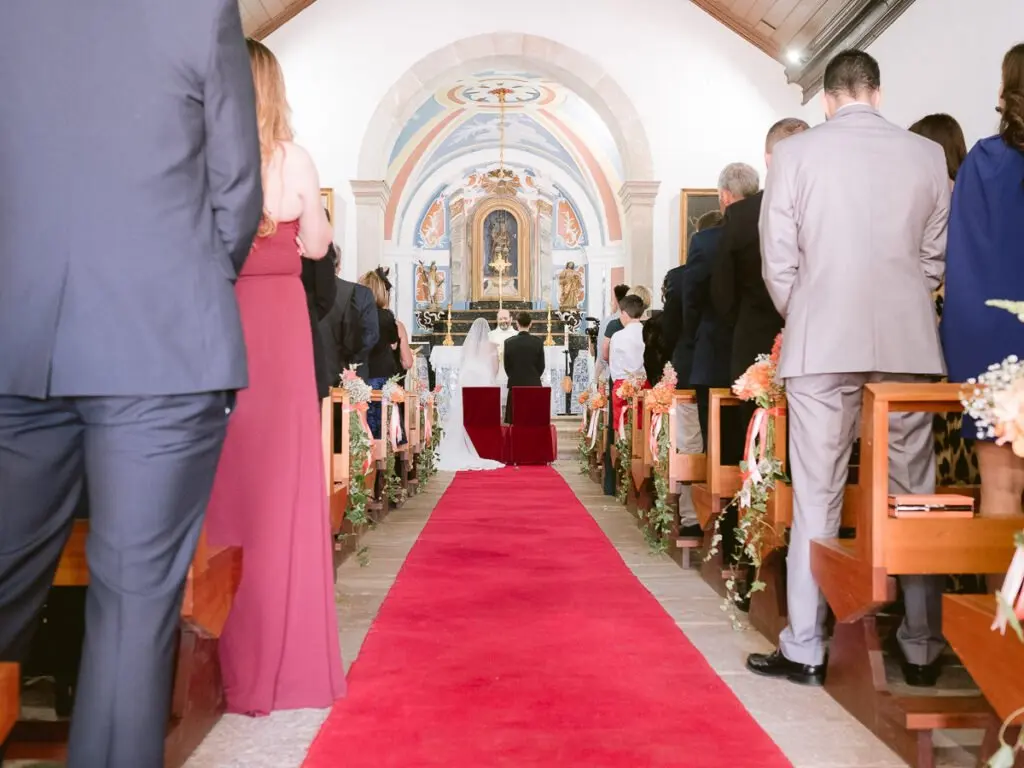 Interior of the chapel at the Farol da Guia Lighthouse with ambient light during a wedding ceremony