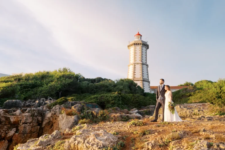 Casal de noivos junto ao Farol da Guia em Cascais no dia do seu casamento em sessão fotográfica ao final do dia