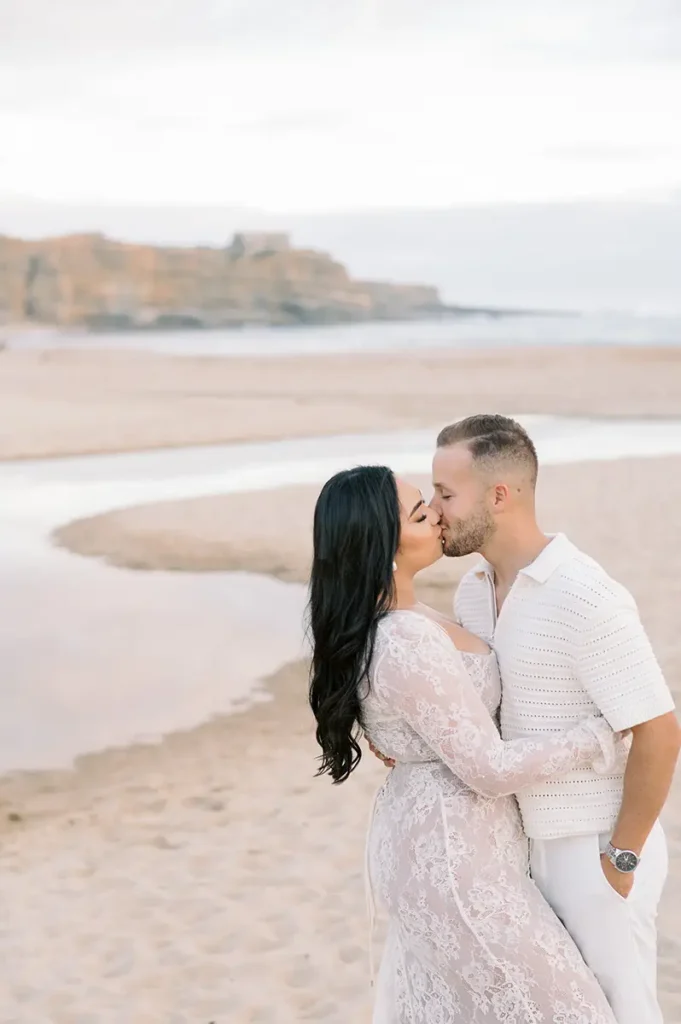 Engaged couple at their pre-wedding session on Ericeira beach in the late afternoon.