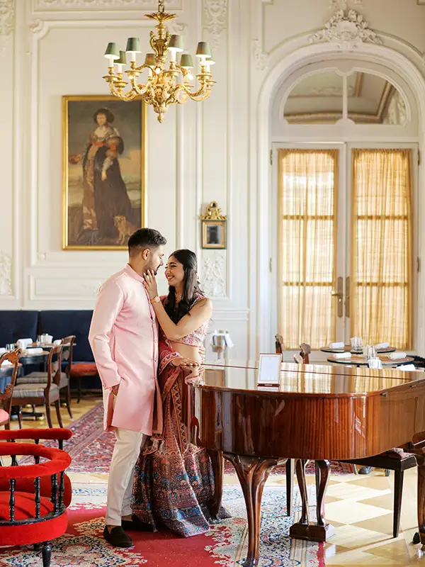 Editorial portrait of Hindu newlyweds in elegant traditional attire during a photo session before the Sangeet party in Portugal, at the Pestana Palace in Lisbon.