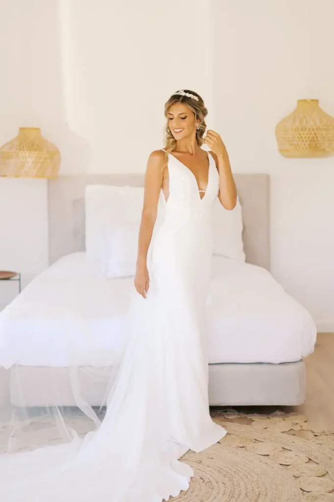 Smiling bride during getting-ready moments in one of the bright rooms at Quinta da Bichinha, highlighting the elegant wedding dress and peaceful atmosphere in Alenquer.