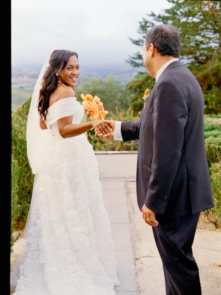 Bride and groom walking through a sun-drenched vineyard in Portugal, captured on Kodak Gold film.