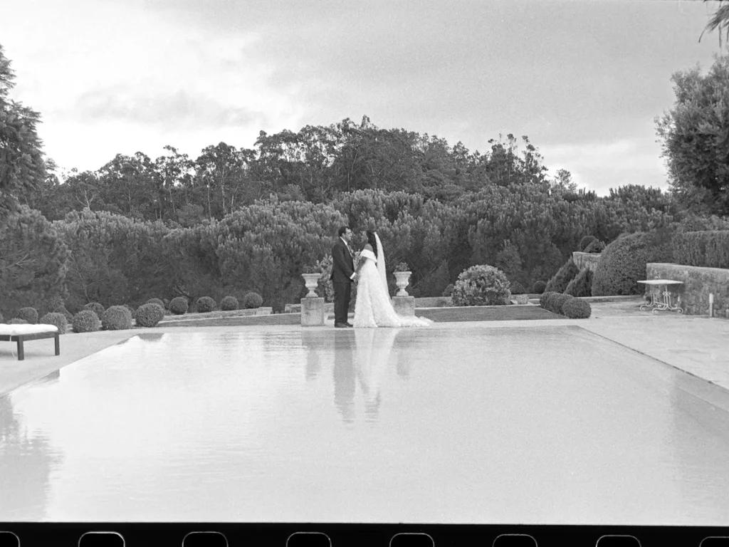 Candid, rustic moment of a bride and groom laughing with guests, black and white analogue photography in Lisbon.